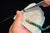 Hands assembling a Rengetsu Ryokuken Green Blade men’s bracelet – mastery
